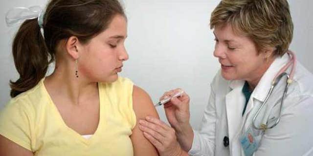 The nurse in this 2006 photograph was in the process of administering an intramuscular vaccination in the left shoulder muscle of a young girl. The nurse was pinching the overlying shoulder skin, in order to immobilize the injection site.