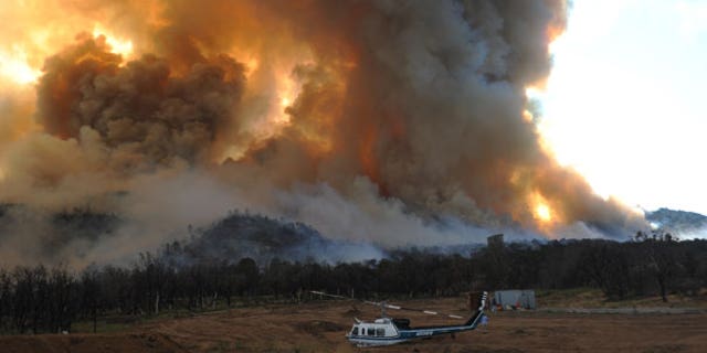 Sept. 4: A damaged helicopter sits as a large wildfire burns to the southwest of Tehachapi, Calif.