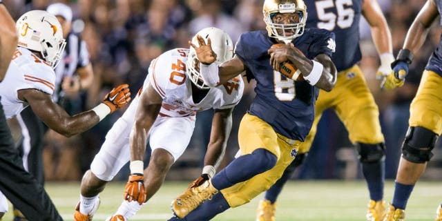 Sep 5, 2015; South Bend, IN, USA; Notre Dame Fighting Irish quarterback Malik Zaire (8) runs the ball as Texas Longhorns defensive end Naashon Hughes (40) pursues in the second quarter at Notre Dame Stadium. Mandatory Credit: Matt Cashore-USA TODAY Sports