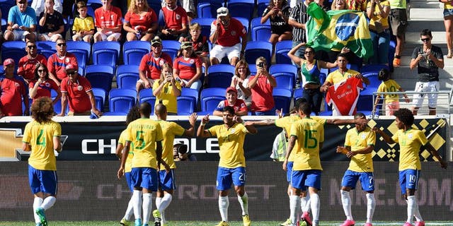 Brazil's Hulk (21) is congratulated by teammates after scoring a goal during the friendly match between Brazil and Costa Rica on September 5, 2015 at Red Bulls Arena in Harrison, New Jersey. AFP PHOTO/DON EMMERT (Photo credit should read DON EMMERT/AFP/Getty Images)