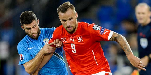 Slovenian defender Bojan Jokic (L) vies with Swiss forward Haris Seferovic during the Euro 2016 qualifying football match between Switzerland and Slovenia at the St. Jakob park stadium in Basel on September 5, 2015. AFP PHOTO / FABRICE COFFRINI (Photo credit should read FABRICE COFFRINI/AFP/Getty Images)