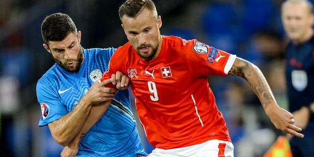 Slovenian defender Bojan Jokic (L) vies with Swiss forward Haris Seferovic during the Euro 2016 qualifying football match between Switzerland and Slovenia at the St. Jakob park stadium in Basel on September 5, 2015. AFP PHOTO / FABRICE COFFRINI (Photo credit should read FABRICE COFFRINI/AFP/Getty Images)