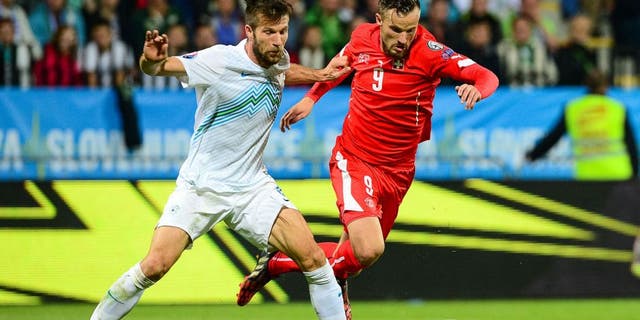 Slovenia's Bostjan Cesar (L) fights for the ball with Switzerland's Haris Seferovic on October 9, 2014 during a Euro 2016 qualifying match Slovenia vs. Switzerland in Maribor, Slovenia. AFP PHOTO / Jure Makovec (Photo credit should read Jure Makovec/AFP/Getty Images)