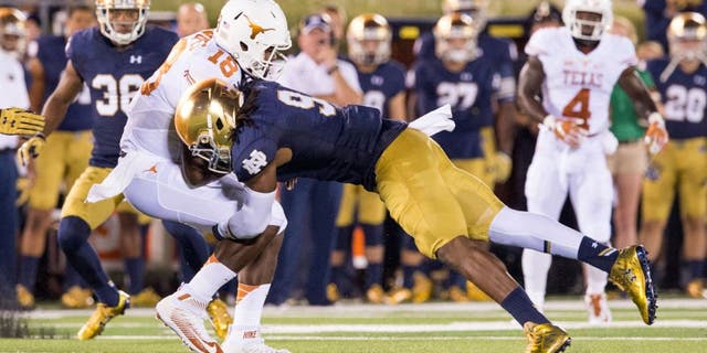 Sep 5, 2015; South Bend, IN, USA; Texas Longhorns quarterback Tyrone Swoopes (18) is tackled by Notre Dame Fighting Irish linebacker Jaylon Smith (9) in the second quarter at Notre Dame Stadium. Mandatory Credit: Matt Cashore-USA TODAY Sports