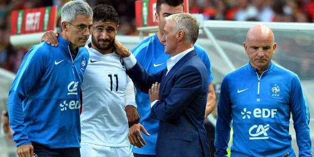 France's forward Nabl Fekir (C) leaves the pitch after injury next to French doctor Franck Le Gall (L), head coach Didier Deschamps and assistant coach Guy Stephan during the Euro 2016 friendly football match Portugal vs France at the Jose Alvalade stadium in Lisbon on September 4, 2015. France won 0-1. AFP PHOTO/ FRANCK FIFE (Photo credit should read FRANCK FIFE/AFP/Getty Images)