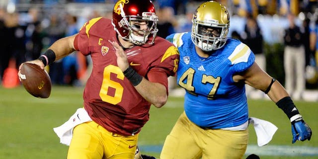 Nov 22, 2014; Pasadena, CA, USA; Southern California Trojans quarterback Cody Kessler (6) is pressured by UCLA Bruins defensive lineman Eddie Vanderdoes (47) and linebacker Deon Hollins (58) during the first half at the Rose Bowl. Mandatory Credit: Richard Mackson-USA TODAY Sports