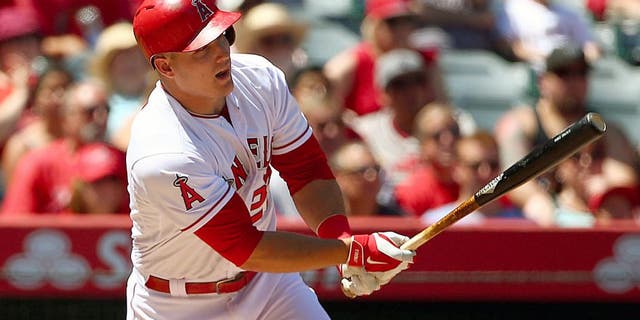 ANAHEIM, CA - SEPTEMBER 06: Mike Trout #27 of the Los Angeles Angels of Anaheim hits a sacrifice fly to center in the second inning as teammate Albert Pujols #5 watches from the on-deck circle during the MLB game against the Texas Rangers at Angel Stadium of Anaheim on September 6, 2015 in Anaheim, California. (Photo by Victor Decolongon/Getty Images)