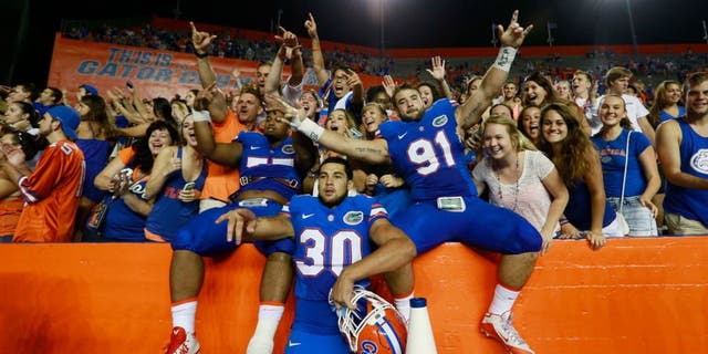 Sep 5, 2015; Gainesville, FL, USA; Florida Gators defensive lineman Joey Ivie (91), Florida Gators offensive lineman Andrew Mike (77) and teammates celebrate as they beat the New Mexico State Aggies at Ben Hill Griffin Stadium. Florida Gators defeated the New Mexico State Aggies 61-13. Mandatory Credit: Kim Klement-USA TODAY Sports