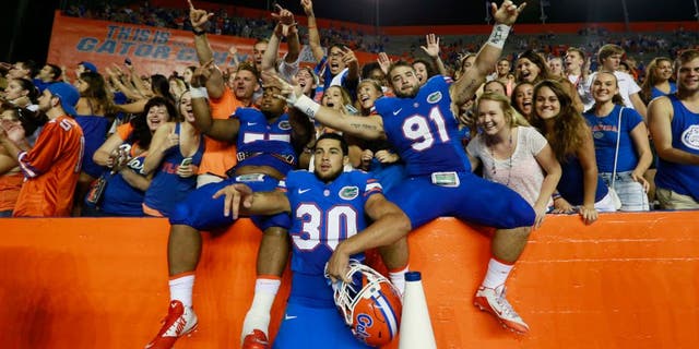 Sep 5, 2015; Gainesville, FL, USA; Florida Gators defensive lineman Joey Ivie (91), Florida Gators offensive lineman Andrew Mike (77) and teammates celebrate as they beat the New Mexico State Aggies at Ben Hill Griffin Stadium. Florida Gators defeated the New Mexico State Aggies 61-13. Mandatory Credit: Kim Klement-USA TODAY Sports
