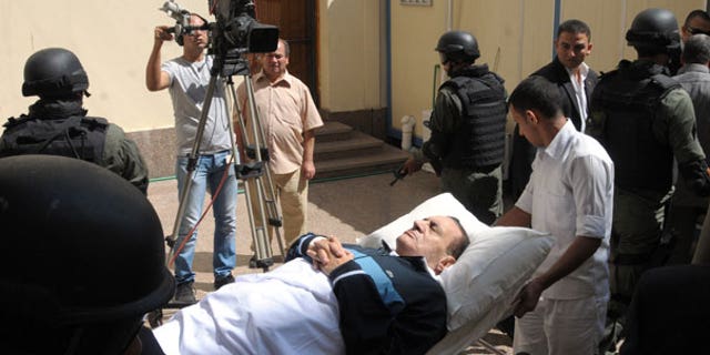 Sept. 7: Former Egyptian president Hosni Mubarak lies on his bed while being taken to the courtroom for another session of his trial in Cairo, Egypt.