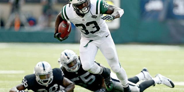 EAST RUTHERFORD, NJ - SEPTEMBER 07: Chris Ivory #33 of the New York Jets rushes after evading tackle attempts by T.J. Carrie #38 and Sio Moore #55 of the Oakland Raiders during the third quarter of a game at MetLife Stadium on September 7, 2014 in East Rutherford, New Jersey. (Photo by Jeff Zelevansky/Getty Images)