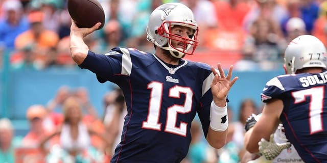 Sep 7, 2014; Miami Gardens, FL, USA; New England Patriots quarterback Tom Brady (12) drops back to pass in the first quarter against the Miami Dolphins at Sun Life Stadium. Mandatory Credit: Brad Barr-USA TODAY Sports