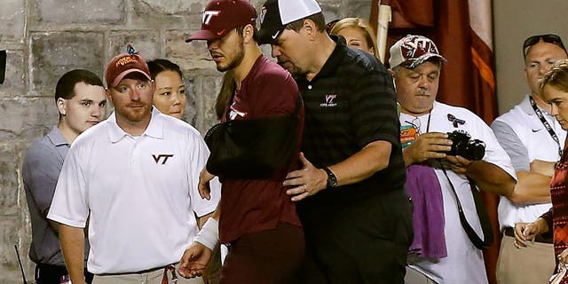 Sep 7, 2015; Blacksburg, VA, USA; Virginia Tech Hokies quarterback Michael Brewer (middle) leaves the field with his left arm in a sling after being injured against the Ohio State Buckeyes in the third quarter at Lane Stadium. Mandatory Credit: Geoff Burke-USA TODAY Sports