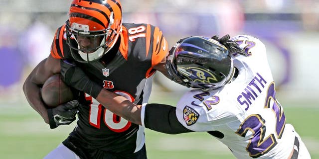 Sep 7, 2014; Baltimore, MD, USA; Cincinnati Bengals wide receiver A.J. Green (18) is tackled after a catch by Baltimore Ravens cornerback Jimmy Smith (22) at M&T Bank Stadium. Mandatory Credit: Mitch Stringer-USA TODAY Sports