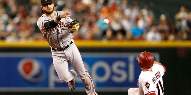 PHOENIX, AZ - SEPTEMBER 07: Infielder Brandon Crawford #35 of the San Francisco Giants throws over the sliding A.J. Pollock #11 of the Arizona Diamondbacks to complete a double play during the first inning of the MLB game at Chase Field on September 7, 2015 in Phoenix, Arizona. (Photo by Christian Petersen/Getty Images)