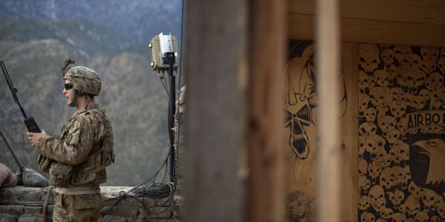 Sgt. Matt Murray, 25, of Warwick, RI., with the U.S. Army's Bravo Company of the 25th Infantry Division, 3rd Brigade Combat Team, 2nd Battalion 27th Infantry Regiment based in Schofield Barracks, Hawaii, listens to the radio next to graffiti left by a previous unit after receiving reports of an impending attack by insurgents Friday, Sept. 9, 2011 at Observation Post Coleman in Kunar province, Afghanistan.