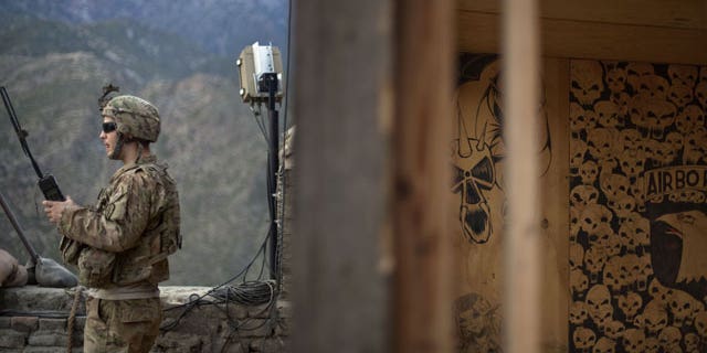 Sgt. Matt Murray, 25, of Warwick, RI., with the U.S. Army's Bravo Company of the 25th Infantry Division, 3rd Brigade Combat Team, 2nd Battalion 27th Infantry Regiment based in Schofield Barracks, Hawaii, listens to the radio next to graffiti left by a previous unit after receiving reports of an impending attack by insurgents Friday, Sept. 9, 2011 at Observation Post Coleman in Kunar province, Afghanistan.