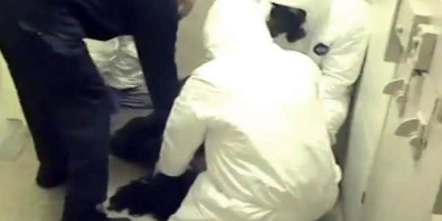 In this Feb. 3, 2015 frame from video provided by the Fairfax County, Va., Sheriff, deputies work to restrain Natasha McKenna during a cell transfer, in Fairfax, Va.