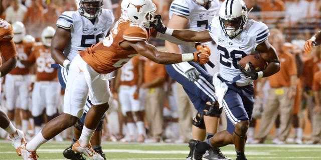 Sep 6, 2014; Austin, TX, USA; Brigham Young Cougars running back Adam Hine (28) runs for a touchdown against Texas Longhorns safeties Adrian Colbert (l) and Mykkele Thompson (2) during the second half at Darrell K Royal-Texas Memorial Stadium. BYU beat Texas 41-7. Mandatory Credit: Brendan Maloney-USA TODAY Sports