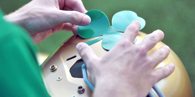 Sept. 10, 2011; Ann Arbor, MI, USA; A student manager applies a shamrock decal to a Notre Dame helmet before the game between the Notre Dame Fighting Irish and the Michigan Wolverines at Michigan Stadium. Mandatory Credit: Matt Cashore-USA TODAY Sports