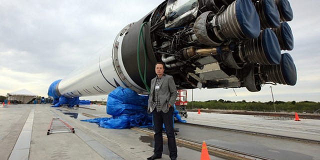 SpaceX CEO Elon Musk stands next to the company's Falcon 9 rocket, which blasted SpaceX's Dragon capsule into orbit in December 2010.