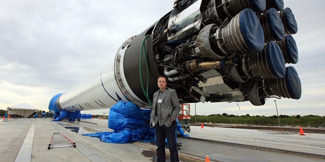 SpaceX CEO Elon Musk stands next to the company's Falcon 9 rocket, which blasted SpaceX's Dragon capsule into orbit in December 2010.