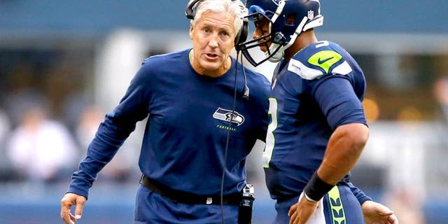 SEATTLE, WA - AUGUST 15: Quarterback Russell Wilson #3 of the Seattle Seahawks talks with head coach Pete Carroll against the San Diego Chargers at CenturyLink Field on August 15, 2014 in Seattle, Washington. (Photo by Otto Greule Jr/Getty Images)
