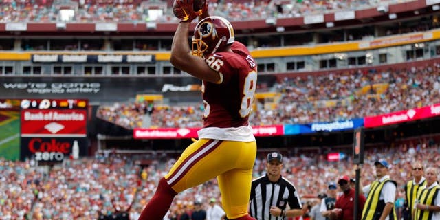 Washington Redskins tight end Jordan Reed (86) catches a touchdown pass over Miami Dolphins strong safety Reshad Jones (20) during the first half of an NFL football game Sunday, Sept. 13, 2015, in Landover, Md. (AP Photo/Patrick Semansky)