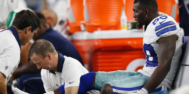 Sep 13, 2015; Arlington, TX, USA; Dallas Cowboys receiver Dez Bryant (88) gets his right ankle worked on by trainers while on the bench in the fourth quarter against the New York Giants at AT&T Stadium. Mandatory Credit: Matthew Emmons-USA TODAY Sports