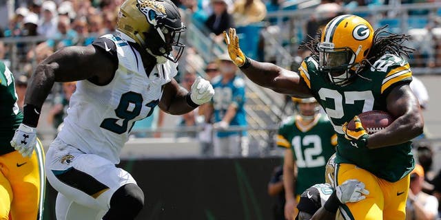 Sep 11, 2016; Jacksonville, FL, USA; Green Bay Packers running back Eddie Lacy (27) runs with he ball as Jacksonville Jaguars outside linebacker Telvin Smith (50) and defensive end Yannick Ngakoue (91) defends during the first half at EverBank Field. Mandatory Credit: Kim Klement-USA TODAY Sports