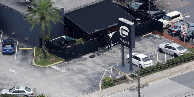 FILE - In this June 12, 2016 file photo, law enforcement officials work at the Pulse gay nightclub in Orlando, Fla., following a mass shooting.