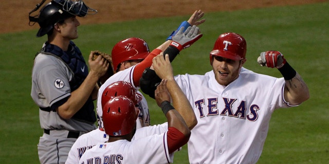 Sept. 14: Cleveland Indians catcher Lou Marson, left, stands by the plate as Texas Rangers' Josh Hamilton, right, is congratulated by teammates Elvis Andrus (1), Ian Kinsler, second from bottom, and Craig Gentry, third from bottom, following Hamilton's grand slam off Indians starting pitcher David Huff in the fourth inning of a baseball game in Arlington, Texas.
