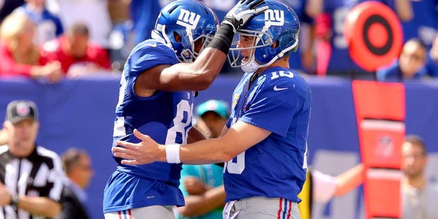 Sep 14, 2014; East Rutherford, NJ, USA; New York Giants quarterback Eli Manning (10) and New York Giants wide wreceiver Rueben Randle (82) celebrate their touchdown against the Arizona Cardinals during the second quarter at MetLife Stadium. Mandatory Credit: Brad Penner-USA TODAY Sports
