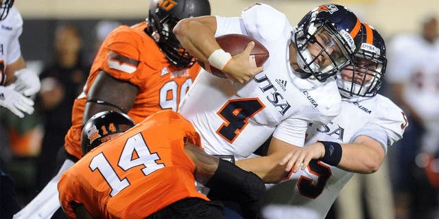 Sep 13, 2014; Stillwater, OK, USA; UTSA Roadrunners quarterback Blake Bogenschutz (4) carries the ball while being tackled by Oklahoma State Cowboys linebacker Josh Furman (14) during the fourth quarter at Boone Pickens Stadium. Mandatory Credit: Mark D. Smith-USA TODAY Sports