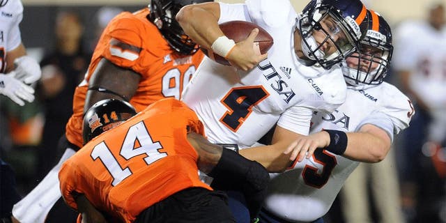 Sep 13, 2014; Stillwater, OK, USA; UTSA Roadrunners quarterback Blake Bogenschutz (4) carries the ball while being tackled by Oklahoma State Cowboys linebacker Josh Furman (14) during the fourth quarter at Boone Pickens Stadium. Mandatory Credit: Mark D. Smith-USA TODAY Sports