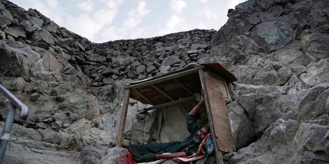In this Friday, Sept. 9, 2016 photo, a Pakistani beggar who sleeps on Noor Mountain, where Prophet Muhammad received his first revelation from God to preach Islam, poses for a portrait, on the outskirts of Mecca, Saudi Arabia.