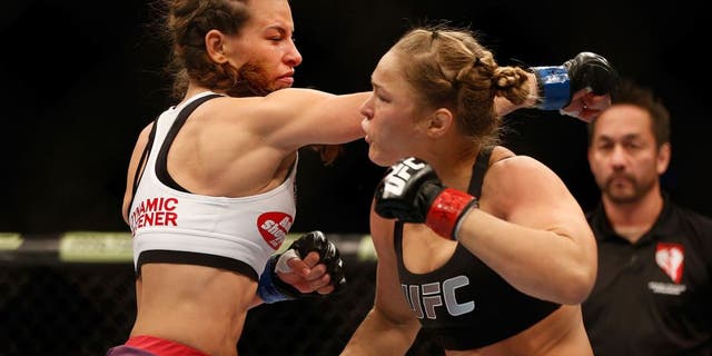 LAS VEGAS, NV - DECEMBER 28: (L-R) Miesha Tate punches Ronda Rousey in their UFC women's bantamweight championship bout during the UFC 168 event at the MGM Grand Garden Arena on December 28, 2013 in Las Vegas, Nevada. (Photo by Josh Hedges/Zuffa LLC/Zuffa LLC via Getty Images) *** Local Caption *** Ronda Rousey; Miesha Tate