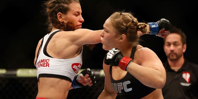 LAS VEGAS, NV - DECEMBER 28: (L-R) Miesha Tate punches Ronda Rousey in their UFC women's bantamweight championship bout during the UFC 168 event at the MGM Grand Garden Arena on December 28, 2013 in Las Vegas, Nevada. (Photo by Josh Hedges/Zuffa LLC/Zuffa LLC via Getty Images) *** Local Caption *** Ronda Rousey; Miesha Tate