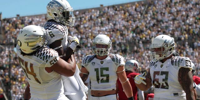 Aug 31, 2013; Eugene, OR, USA; Oregon Ducks running back De'Anthony Thomas (6) is lifted into the air by offensive linesman Hamani Stevens (54) while tight end Colt Lyerla (15) and offensive linesman Mana Greig (63) celebrate a touchdown against the Nicholls State Colonels at Autzen Stadium. Mandatory Credit: Scott Olmos-USA TODAY Sports