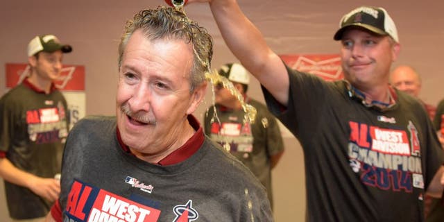 Sep 17, 2014; Anaheim, CA, USA; Los Angeles Angels owner Arte Moreno (left) celebrates with third base coach Gary DiSarcina after winning the American League West Division title against the Seattle Mariners at Angel Stadium of Anaheim. Mandatory Credit: Kirby Lee-USA TODAY Sports