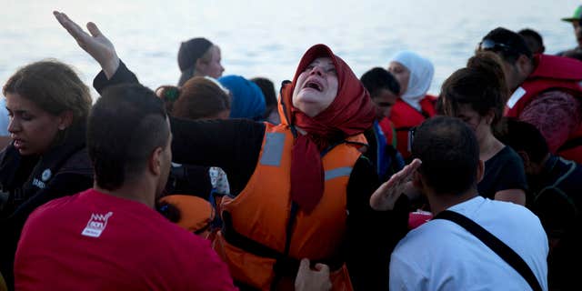 Sept. 19, 2015: A woman reacts as she arrives aboard a dinghy after crossing from Turkey, to the island of Lesbos, Greece
