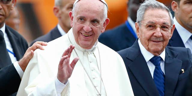 Sept. 19, 2015: Pope Francis waves next to Cuba's President Raul Castro during his arrival ceremony at the airport in Havana, Cuba.