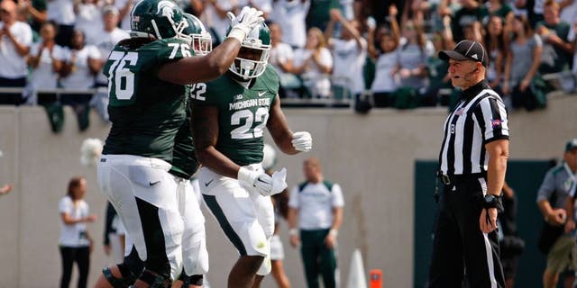 Sep 20, 2014; East Lansing, MI, USA; Michigan State Spartans running back Delton Williams (22) celebrates after a touchdown during the second quarter against the Eastern Michigan Eagles at Spartan Stadium. Mandatory Credit: Raj Mehta-USA TODAY Sports