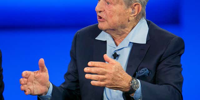 FILE - In this Sept. 27, 2015, file photo, George Soros, chairman of Soros Fund Management, talks during a television interview for CNN at the Clinton Global Initiative in New York.