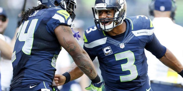Sep 21, 2014; Seattle, WA, USA; Seattle Seahawks quarterback Russell Wilson (3) celebrates with Seattle Seahawks running back Marshawn Lynch (24) after a touchdown pass during the second quarter against the Denver Broncos at CenturyLink Field. Mandatory Credit: Joe Nicholson-USA TODAY Sports