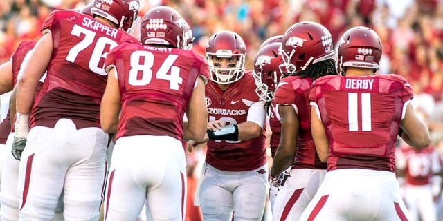 Sep 20, 2014; Fayetteville, AR, USA; Arkansas Razorbacks quarterback Brandon Allen (10, center) calls a play as offensive tackle Dan Skipper (74) tight end Henry Hunter (84) tightened A.J. Derby (11) and other players look on during the first half of a game against Northern Illinois Huskies at Donald W. Reynolds Razorback Stadium. Mandatory Credit: Beth Hall-USA TODAY Sports