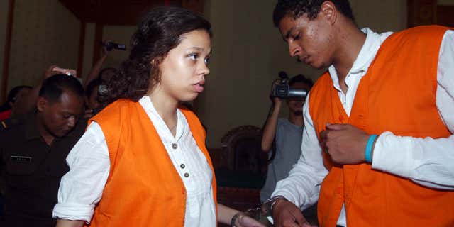 FILE - In this March 31, 2015 file photo, Heather Mack, 19, left, and her boyfriend Tommy Schaefer, 21, of Chicago, are handcuffed as they arrive at a courtroom during their trial in Bali, Indonesia.