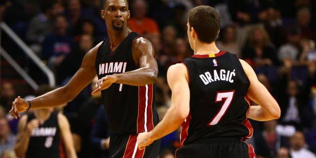 Jan 8, 2016; Phoenix, AZ, USA; Miami Heat center Chris Bosh (1) celebrates a play with guard Goran Dragic (7) against the Phoenix Suns at Talking Stick Resort Arena. The Heat defeated the Suns 103-95. Mandatory Credit: Mark J. Rebilas-USA TODAY Sports