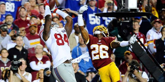 Sep 25, 2014; Landover, MD, USA; New York Giants tight end Larry Donnell (84) catches a touchdown pass as Washington Redskins strong safety Bashaud Breeland (26) defends during the first half at FedEx Field. Mandatory Credit: Brad Mills-USA TODAY Sports