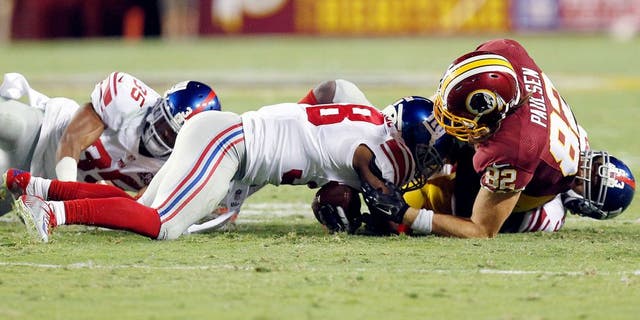 Sep 25, 2014; Landover, MD, USA; New York Giants cornerback Trumaine McBride (38) recovers a fumble by Washington Redskins tight end Logan Paulsen (82) in the second quarter at FedEx Field. Mandatory Credit: Geoff Burke-USA TODAY Sports